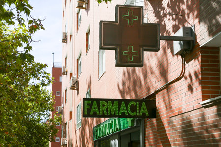 Pharmacy sign at a store selling medical products and drugs in the capital of Spain.の写真素材