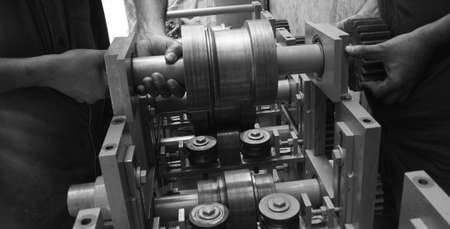 Closeup of a metal shaft parts holding by two persons by hands of Lathe Machinery. Vintage...