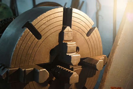 Closeup of an old Lathe Machinery. lathe chuck and key 4-jaw screw chuck. Vintage Industrial Machinery in a old factory.の写真素材