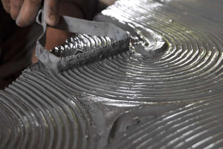 Close up of male sculptor holding tool and making art on clay. Clay master moulding. Clay modelling.の写真素材