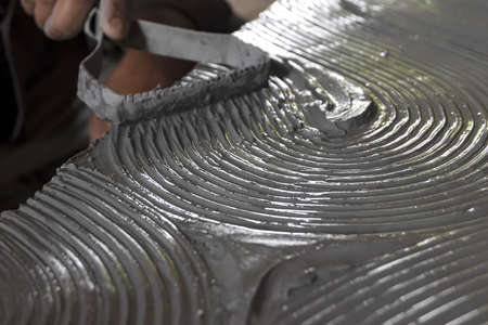 Close up of male sculptor holding tool and making art on clay. Clay master moulding. Clay modelling.の写真素材