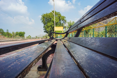 Blank railway sign board, seating bench at railway station platform of an Indian mountain village on a sunny summer day. Indian village.の写真素材