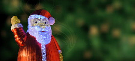 Closeup of a Santa Clause on green bokeh background with floral swirl. Christmas Greeting. Copy Space.の写真素材
