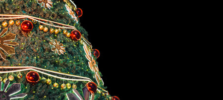 Closeup of a Christmas Tree on black opaque background. Christmas Greeting. Copy Space.の写真素材