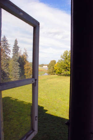 Window to the autumn manor park and the pondの写真素材
