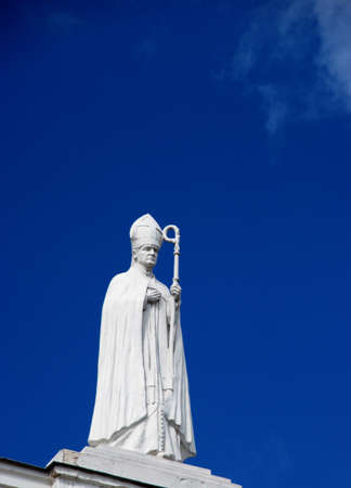 Religious-themed statue of pope with the stick against the sky. の写真素材