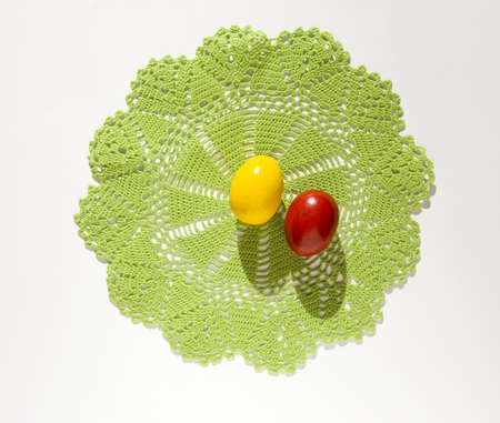 Colorful Easter eggs on a knitted green tissue isolated on a white backgroundの写真素材
