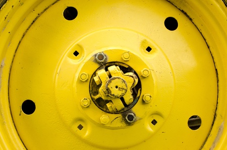 Yellow tractor wheel closeup details bolts nuts holes の写真素材