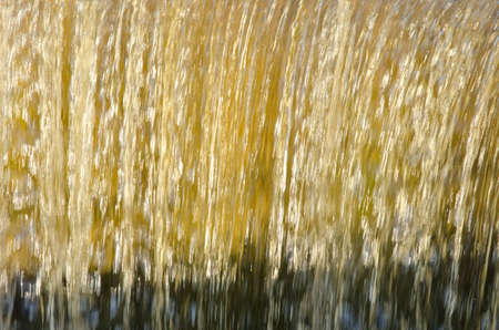 Flow down dam water closeup beautiful sunlit backdrop background. の写真素材