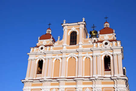 Religious building wall and towers cross church in Vilnius on background of blue sky  