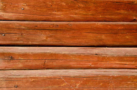 Background of ancient shaved painted wooden log wall and rusty nail heads. の写真素材
