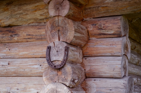 Horseshoe hang on wooden log house corner  Sign symbol of luck  の写真素材