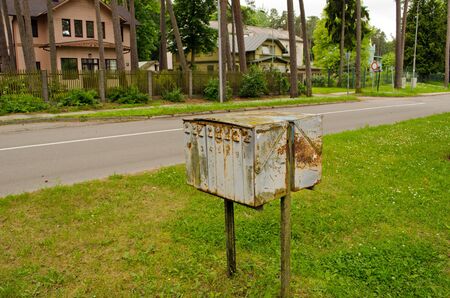 Old corroded rusty mailboxes near retro wooden houses district  の写真素材