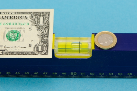 spirit level tool and usd dollar banknote and euro coin on blue background  の写真素材