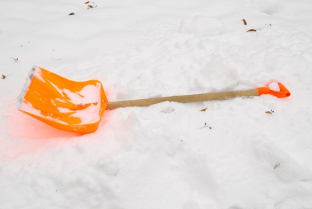 orange plastic snow clean tool lie rest on snowdrift in winter. の写真素材