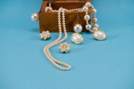 pearl jewelry beads necklace earring in retro wooden box on blue background  の写真素材