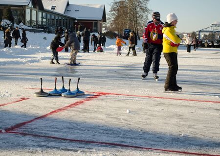 TRAKAI, LITHUANIA - CIRCA JANUARY 2013 - people play winter game curling eisstock and slide skating...