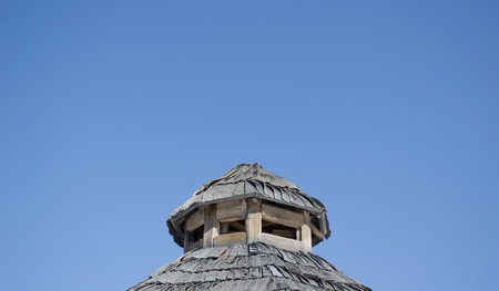 vintage old rural house roof coated with wooden tiles on background of blue sky. の写真素材