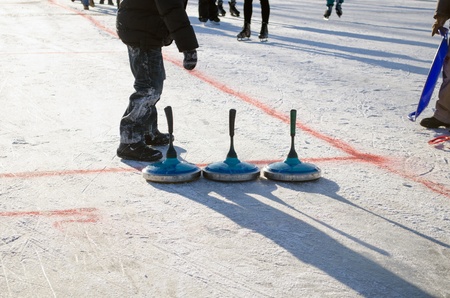 people play winter game curling eisstock and slide skate playground on frozen lake ice. の写真素材