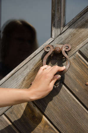 guest hand knock retro rusty metal door handle used as buzzer ringer knocker. の写真素材