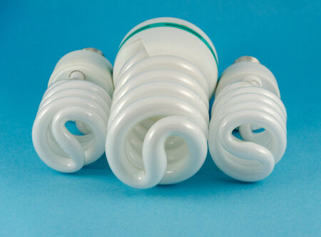 three eco economy fluorescent lamp on blue background 
