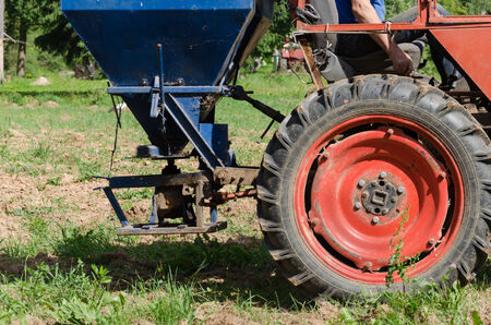 Follow retro tractor wheels and seeder equipment sow buckwheat seeds in agriculture field. の写真素材