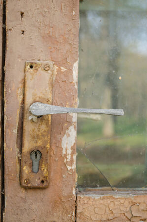 rusty door fragment with old paint scratched door handle with key hole の写真素材