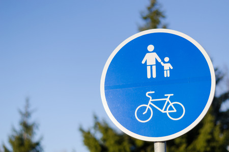 bicycle and pedestrian lane road sign on pole post in blue, walkway footpath route traffic roadside traffic sign の写真素材
