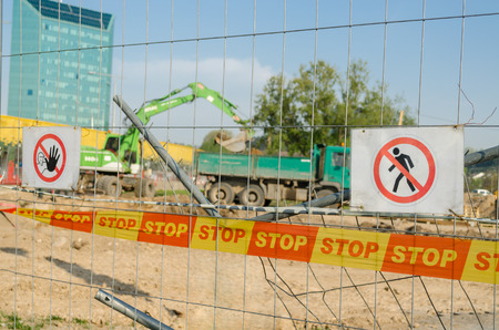 iron fence with security tape stop and warning do not enter sign the construction site in the city の写真素材