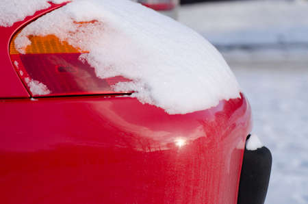 red car front lamp covered with powdery snow in cold winter weather の写真素材