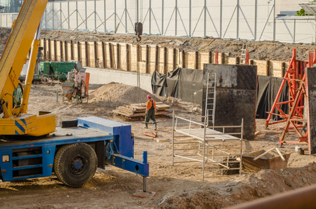 construction site with workers heavy machinery foundations handling and scaffolding 