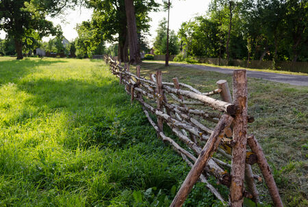 antique rustic rural style twisted fence of thin branches along the road の写真素材