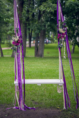 the wedding of the swing to the tree colors red, purple and white roses, ribbons developingの写真素材