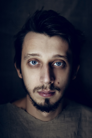 portrait of a serious young guy with a beard and a mustache shirt grey flaxの写真素材