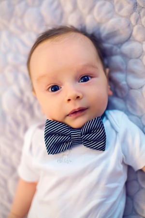 child bow tie butterfly rests on a light bed