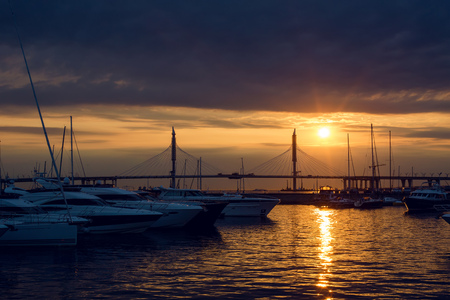 yacht standing at the pier at sunset in summer, in the distance, the cable-stayed bridgeの写真素材