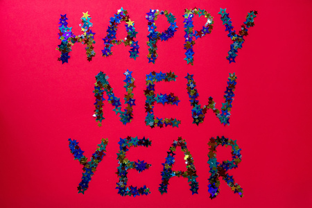 inscription colored stars new year on a red background with a large festive candyの写真素材