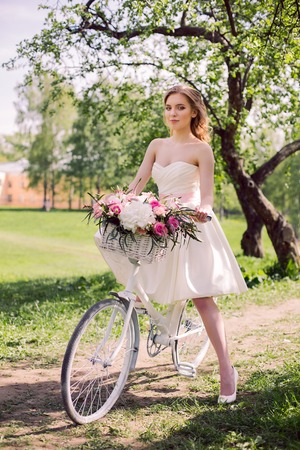 young bride in white dress and with a bouquet in the summer is the tree in the gardenの写真素材