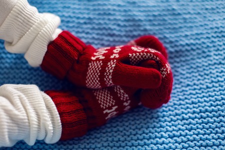 female hands in red mittens and blue scarfの写真素材