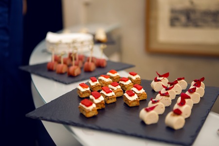 snacks of fish on the black tray