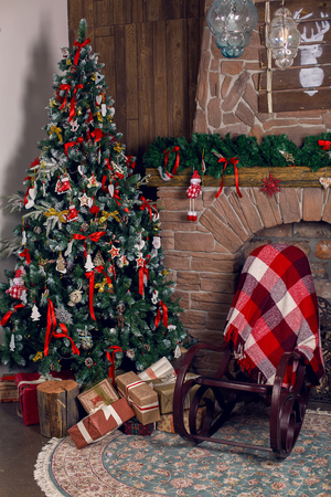 Christmas tree in the room in the snow, decorated with toys and lay next to the gifts in boxesの写真素材