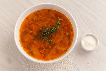 red soup in white plate on the table with sour cream in a white saucerの写真素材