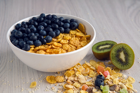 granola with blueberries in white bowl on wooden white backgroundの写真素材