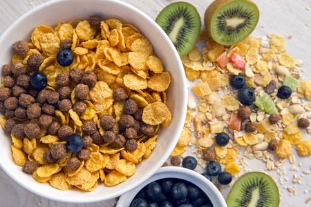 granola with blueberries in white bowl on wooden white backgroundの写真素材