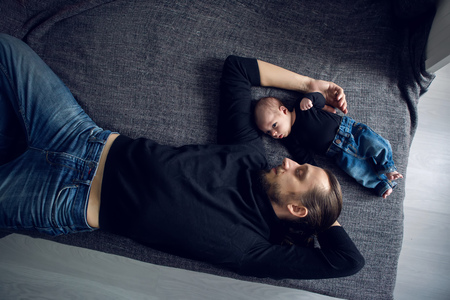 father and son lying on the bedの写真素材