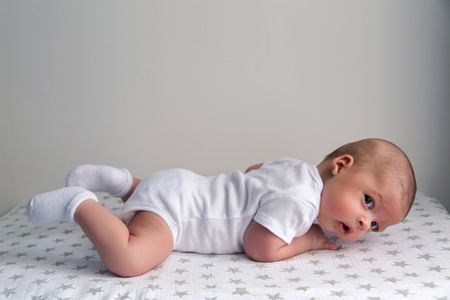 newborn lies on the stomach on a diaper with the stars