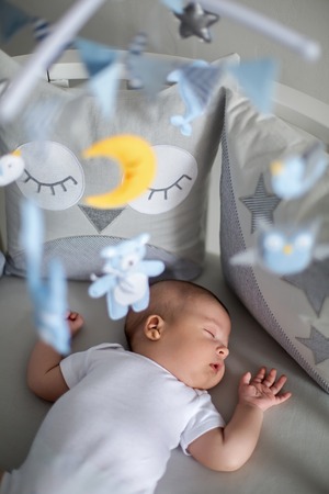 baby boy white t-shirt sleeping in a round bed