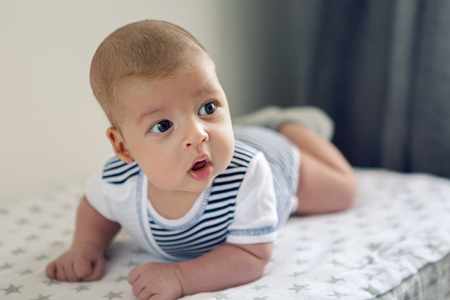 newborn lies on the stomach on a diaper