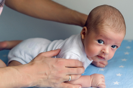father holding a baby lying