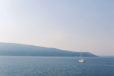 white yacht is in the Bay of Montenegro in the autumn